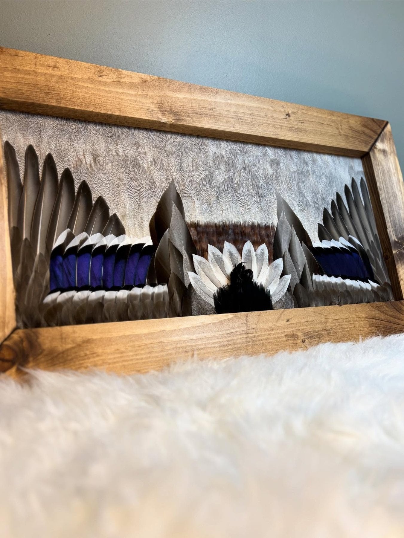 Waterfowl feather artwork with blue accents